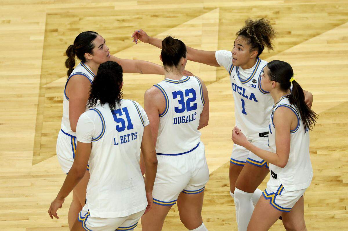 Charlisse Leger-Walker, Lauren Betts (51), Angela Dugalić, Kiki Rice and Gabriela Jaquez of the UCLA Bruins celebrate against the Texas Longhorns in the Final Four of the NCAA Women's Basketball Tournament at Mortgage Matchup Center on April 3, 2026 in Phoenix, Arizona.