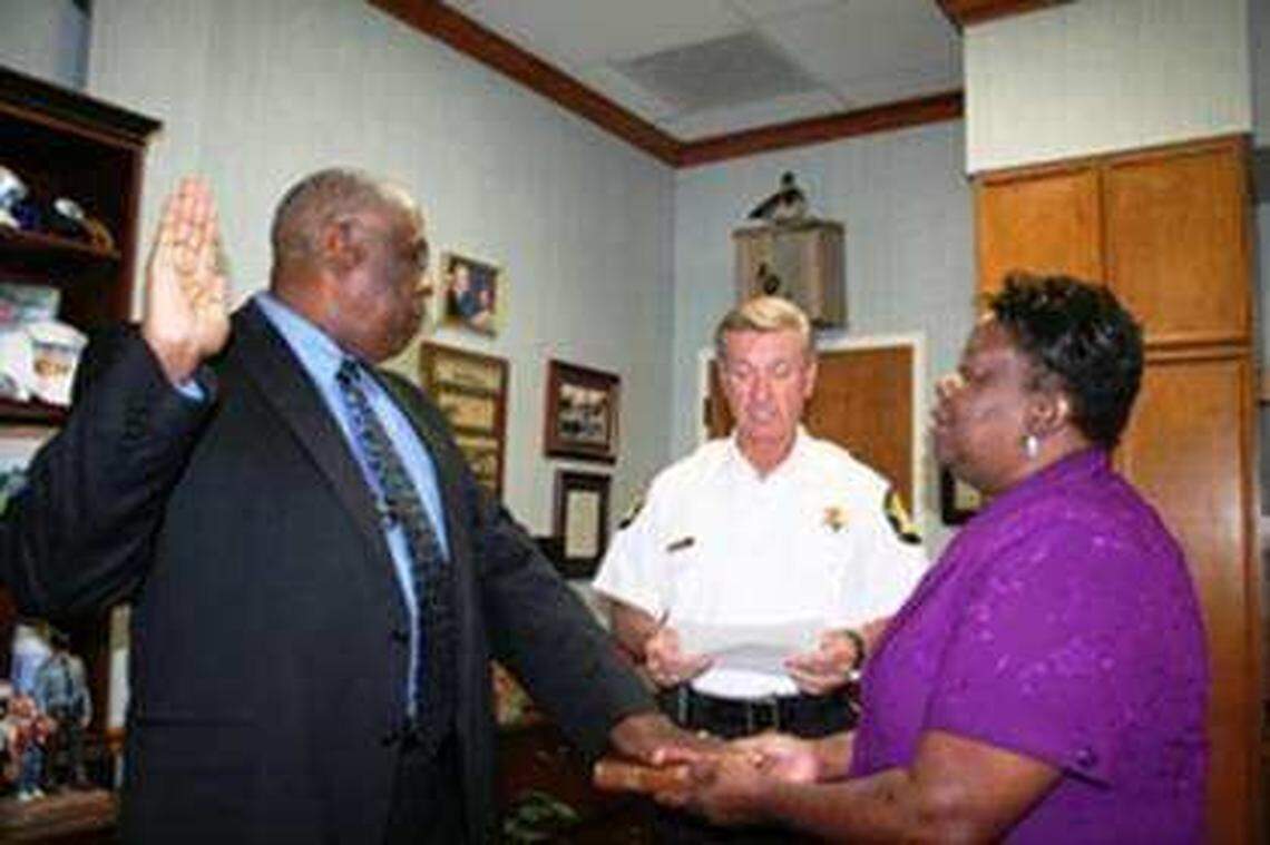 Terry Barrett is sworn in as a Richland County Sheriff’s Department chaplain by Sheriff Leon Lott, as Barrett’s wife, Kathleen, holds a Bible.