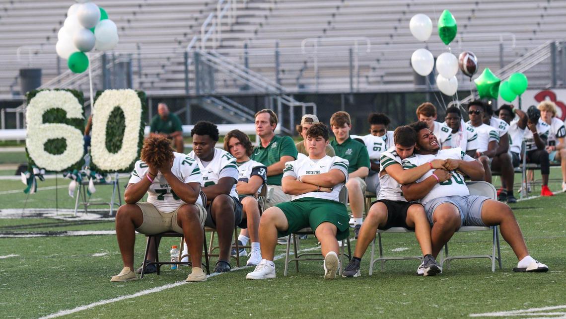 Quarterback Davin Patterson (11) comforts Brandon Murphy (50) during a vigil at Dutch Fork High School, for teammate Jack Alkhatib, a senior and a football player who collapsed and died after practice this week.
