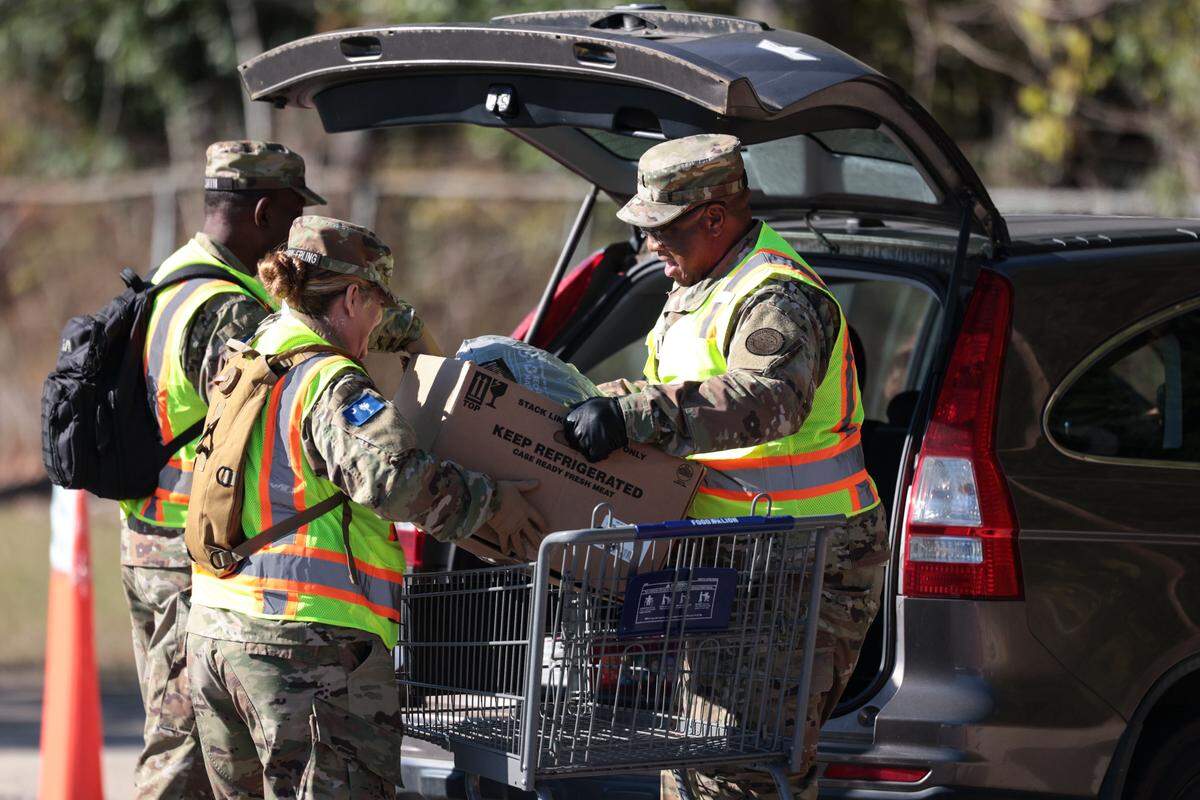 Members of the South Carolina State Guard, including Staff Sgt. James E. Smith, left, Pvt. Tonia Brown-Epling and Lt. Allen Johnson, help load food  Wednesday, Nov. 5, 2025, at the Harvest Hope Food Bank in Columbia. Since the federal government shutdown halted SNAP benefits, the food bank has nearly doubled their daily distribution.