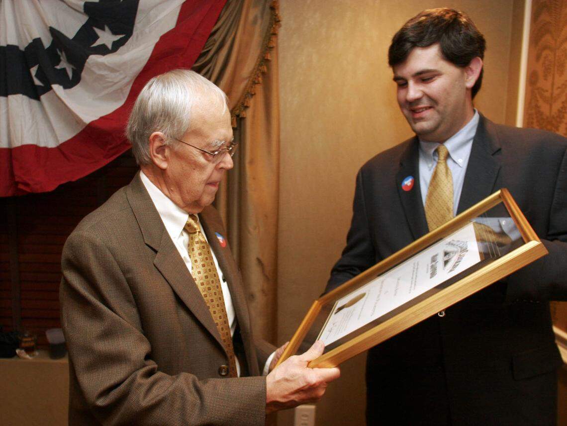 Longtime political writer Lee Bandy left, receives the Order of the Palmetto from Joel Sawyer on behalf of South Carolina Gov. Mark Sanford during a ceremony in January 2007.