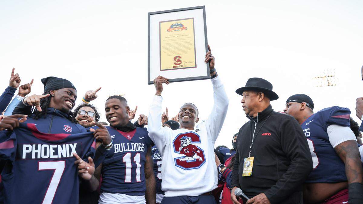 South Carolina State head coach Chennis Berry hoists up a framed invitation to the Cricket Celebration Bowl following South Carolina State’s game against Norfolk State at Oliver C. Dawson Stadium in Orangeburg on Saturday, November 23, 2024.


