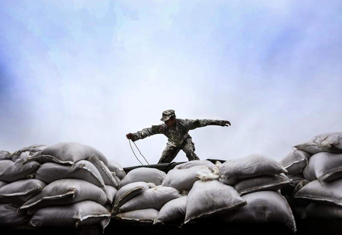 National Guard Sgt. Gerry Ortiz unloads sandbags in Columbia one day before floodwater and rain ravaged the Midlands.