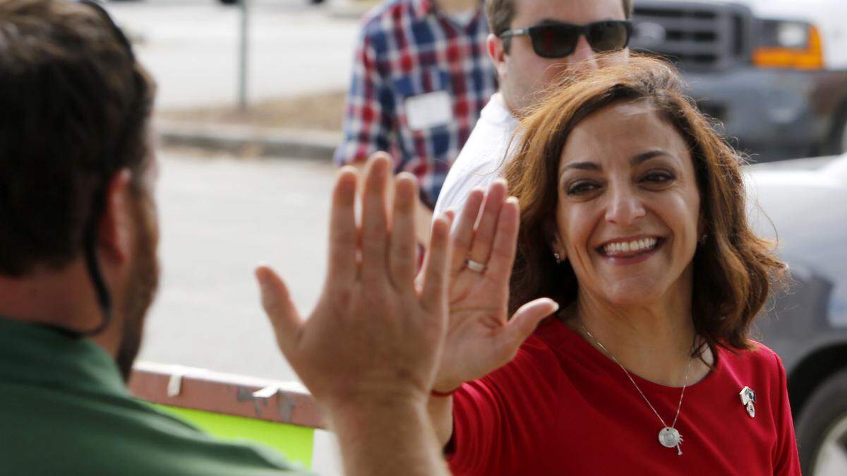 Republican nominee for Congress Katie Arrington high fives a voter at Westview Primary Schools in Goose Creek, S.C., Tuesday, November, 6, 2018.