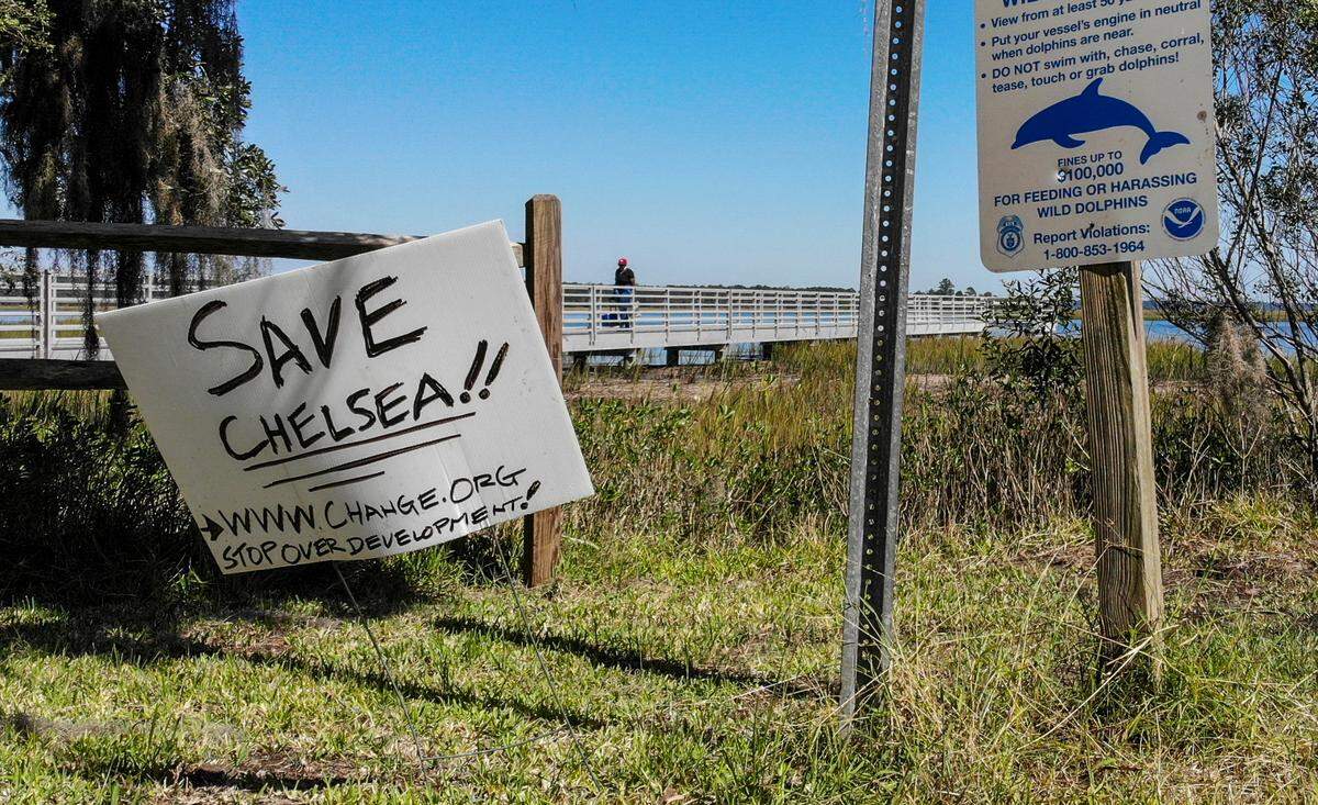 A sign decrying development is seen on Friday, Oct. 14, 2022 as a person walks from the pier at the Bolan Hall Landing in Jasper County.