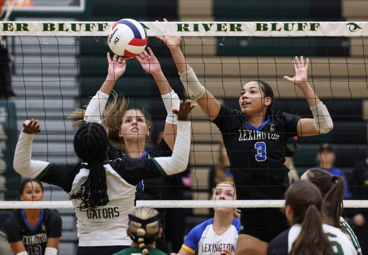 Sydney Fischer (4) and Jazlyn Snow (3) of Lexington go up to block the return of Oprah Tchuendem of River Bluff during Lexington’s game against River Bluff at River Bluff in Columbia on Thursday, October 17, 2024.