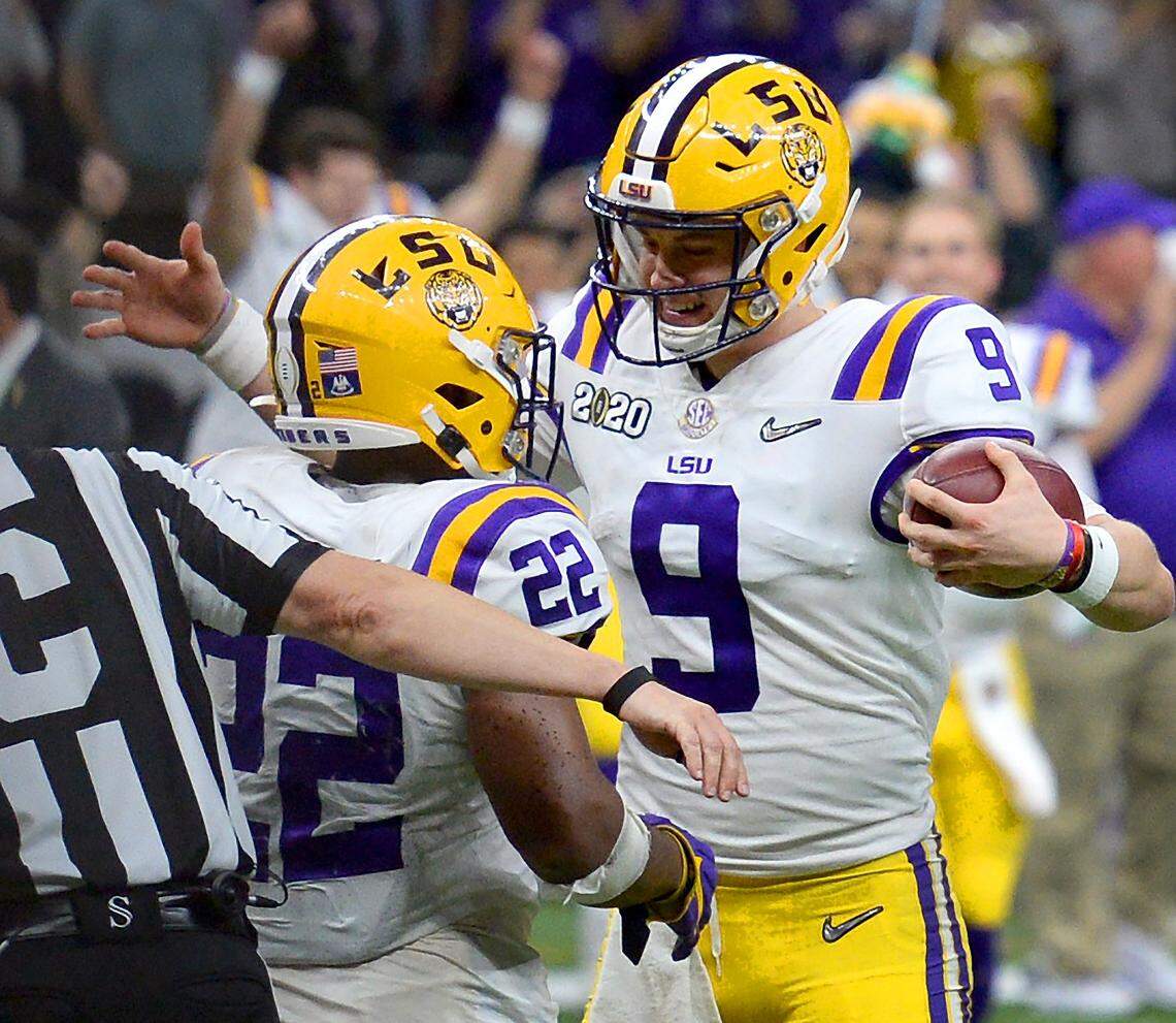 LSU running back Clyde Edwards-Helaire (left) and quarterback Joe Burrow begin to celebrate as time expires at the end of LSU’s 42-25 win over Clemson in the College Football Playoff national championship Monday night.