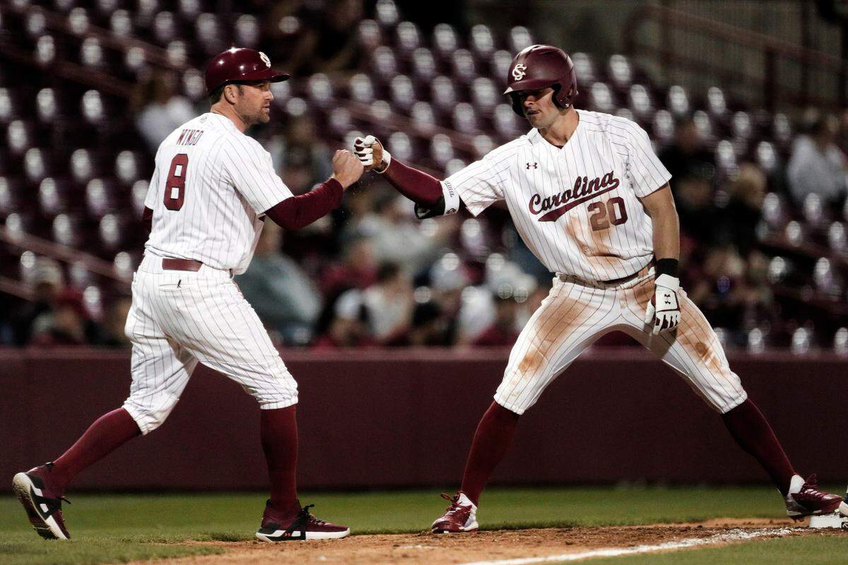 South Carolina assistant coach Scott Wingo celebrates with Matt Hogan, right, after Hogan’s triple against UNC Greensboro on Friday, February 17, 2022.