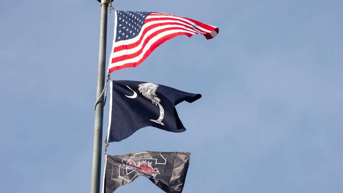 The American, state and University of South Carolina flags fly above the State House on April 7, 2024.