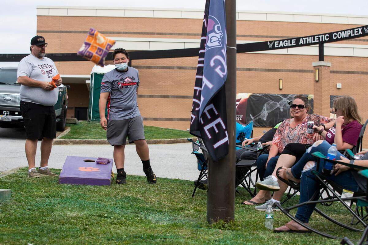 Kevin Sexton and Tucker Houston play corn hole before Erskine College plays Shorter University at Greenwood High School on Saturday, March 13, 2021. Sexton is excited to see his son’s team play, and has become more of a fan of college sports in the last year.