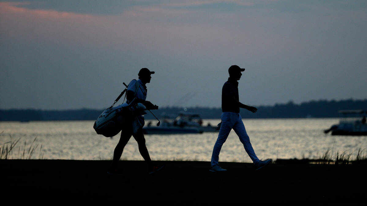 Carlos Ortiz walks with his caddie Eduardo Castillo walk up the 18th fairway during the final round of the RBC Heritage golf tournament June 21, 2020 in Hilton Head Island.