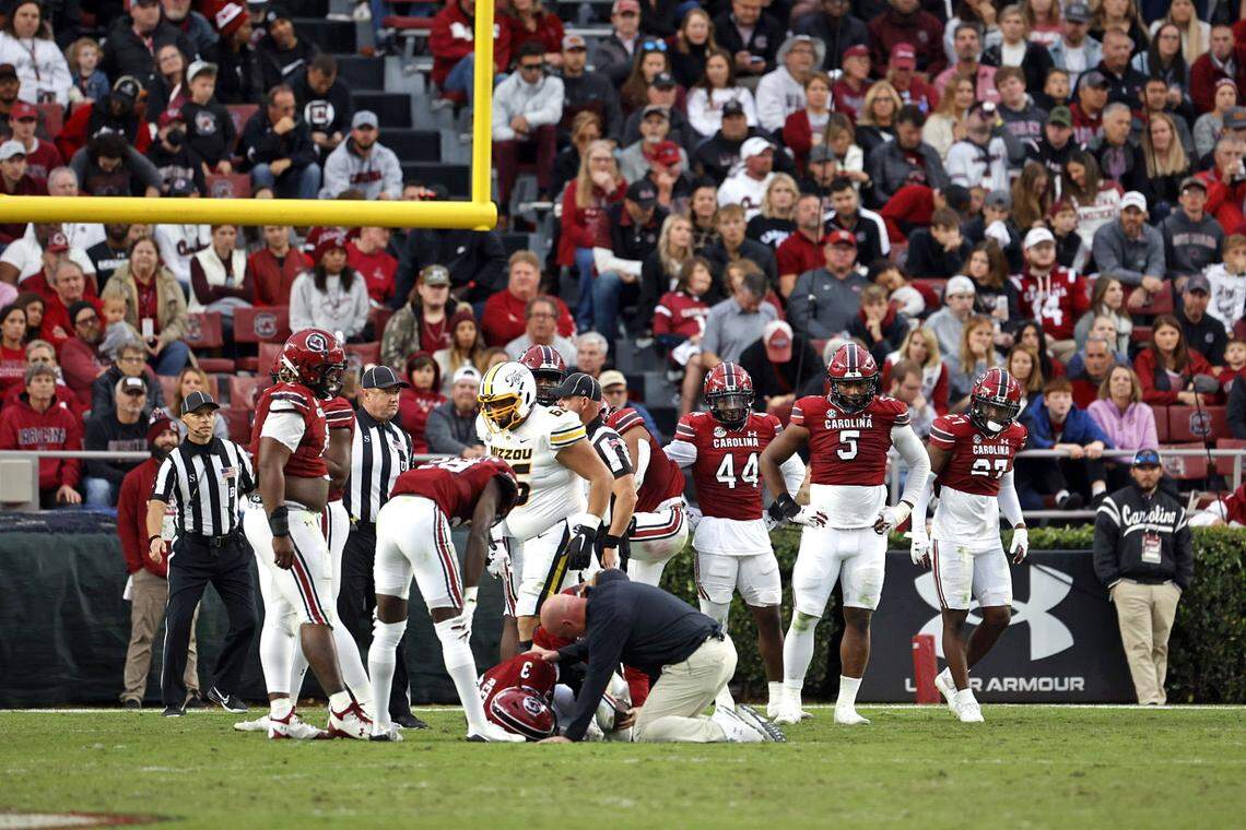 Teammates gather around South Carolina safety Devonni Reed in the third quarter after he appeared to suffer a left leg injury.