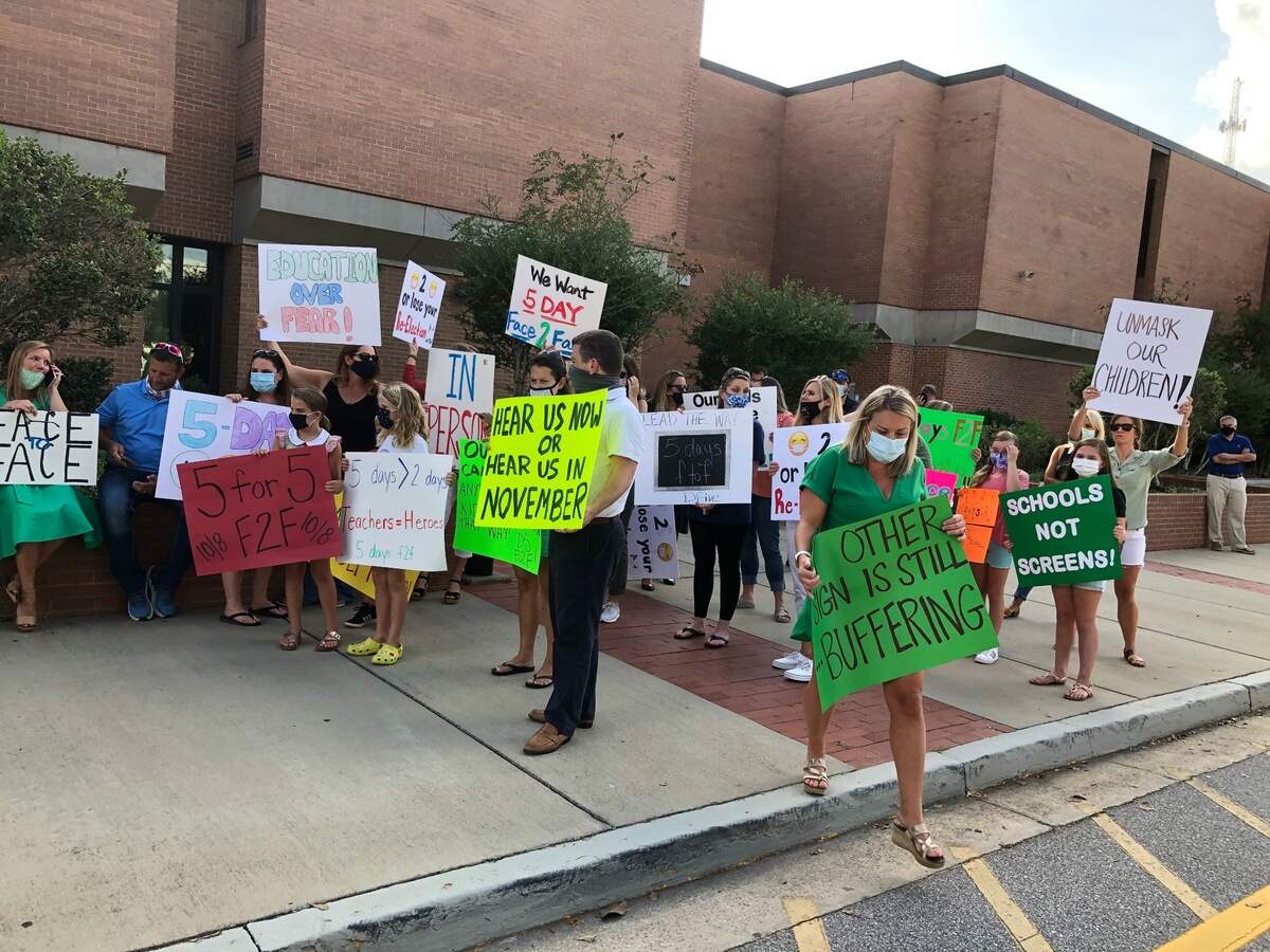 Around 100 parents in Lexington-Richland 5 rallied outside Irmo High School ahead of a school board meeting on Monday. The protesters called on the board to fully reopen schools for five-day-a-week classes by Oct. 8.