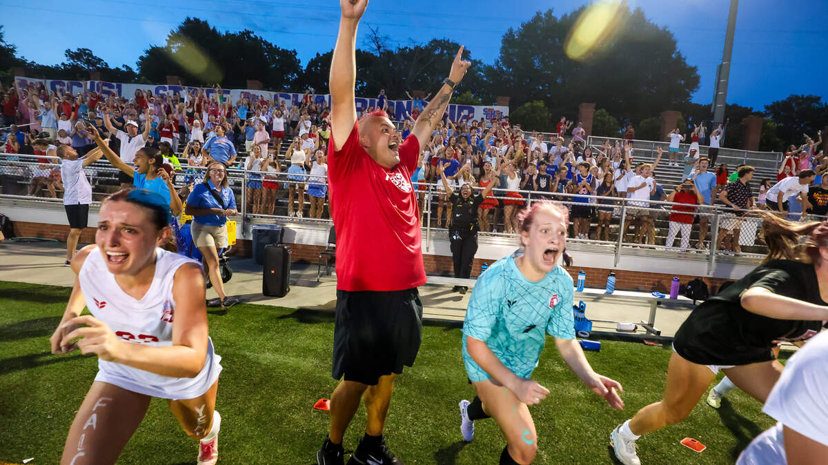 AC Flora Falcons head coach Eric Navarro and his team celebrate as the clock expires against the Bishop England during the state championship game at Memorial Stadium in Columbia, SC, 5/24/25. AC Flora won, 1-0.