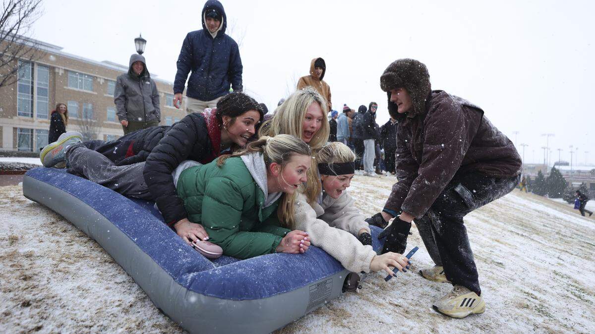 Ella Curry, green jacket Elizabeth Calise, white jacket, Aubrey Harley, black jacket on left, and Brielle Theoret sled down a hill at the athletic fields on the USC Campus on Saturday, Jan. 31, 2026. Snow is expected to fall all day in the Midlands. Calise is the videographer.
