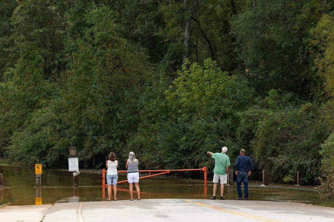 People look out at flooding near the Cayce Tennis & Fitness Center Cayce, South Carolina as the waters recede on Tuesday, October 1, 2024.