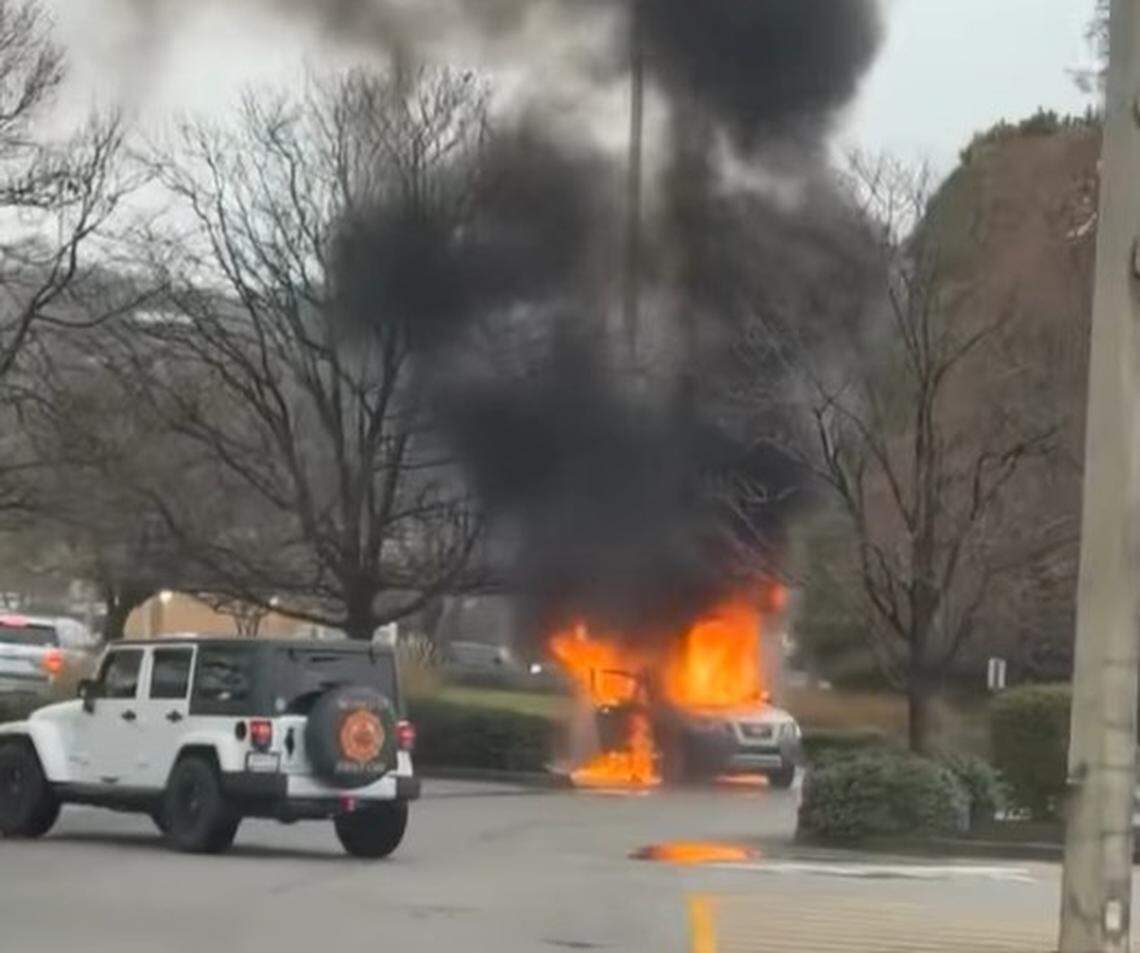 A vehicle went up in flames in a parking lot.