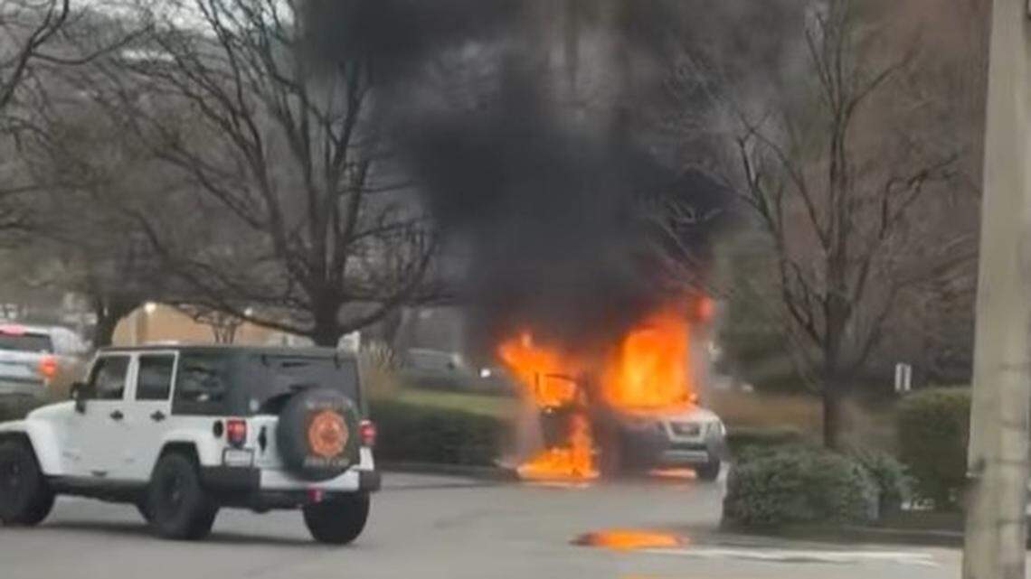 A vehicle went up in flames in a parking lot.