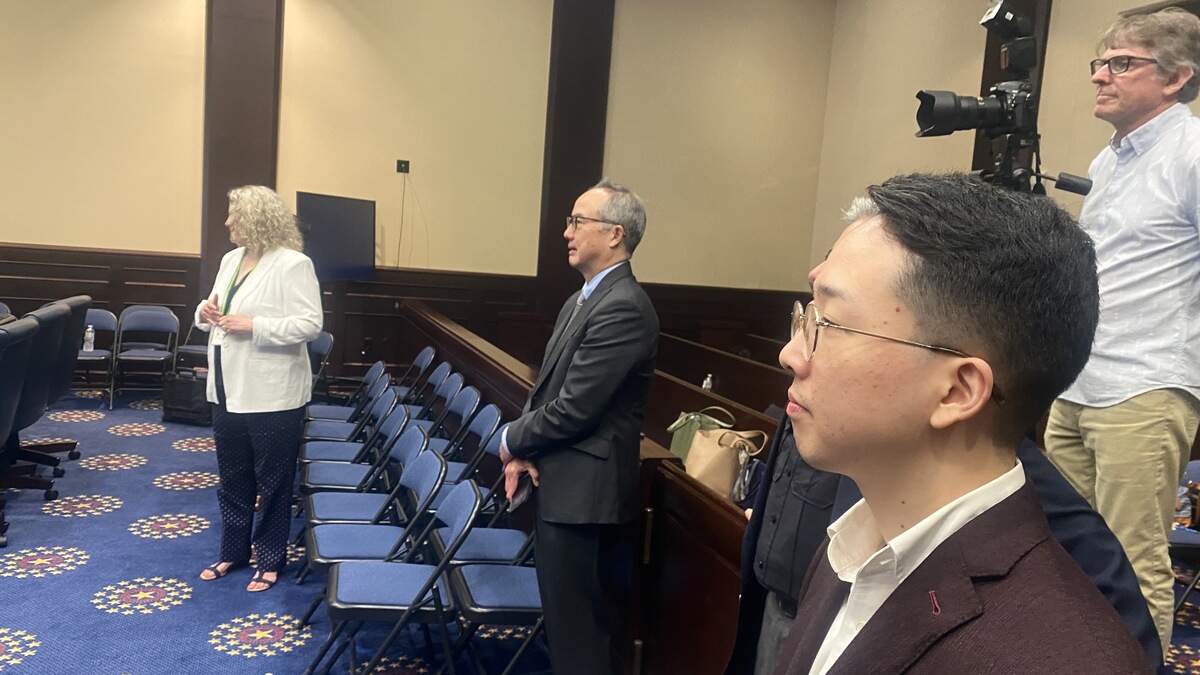 Ian Ishida stands toward the back of the courtroom across from his father, James Ishida, after a naturalization ceremony that drew USC women’s basketball coach Dawn Staley and prominent federal judges.