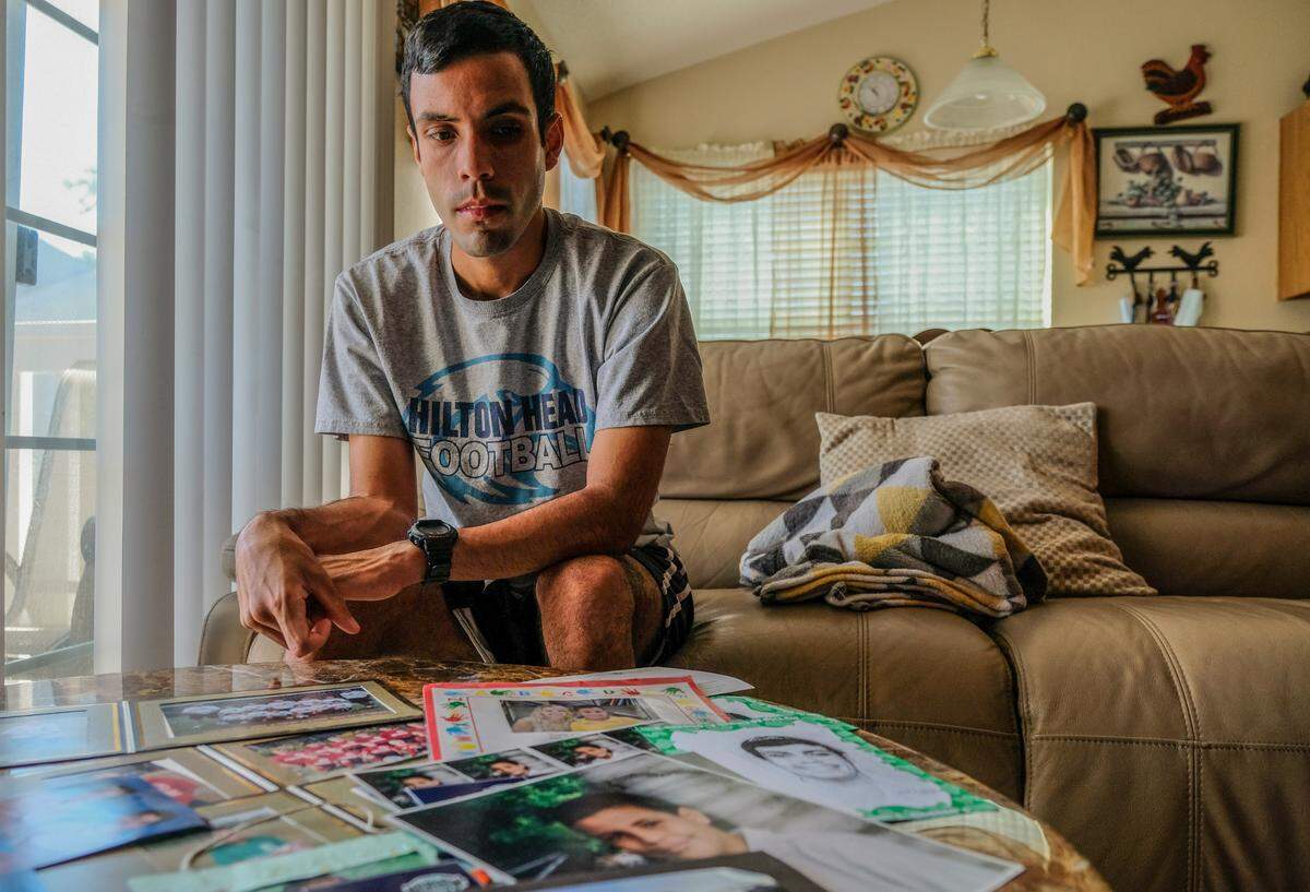 Kebin Lopez, now a graduate student, sits for a portrait in his parents house in Bluffton, S.C. on Thursday, April 22, 2021, with photos and documents he collected from his time on Hilton Head Island schools.
