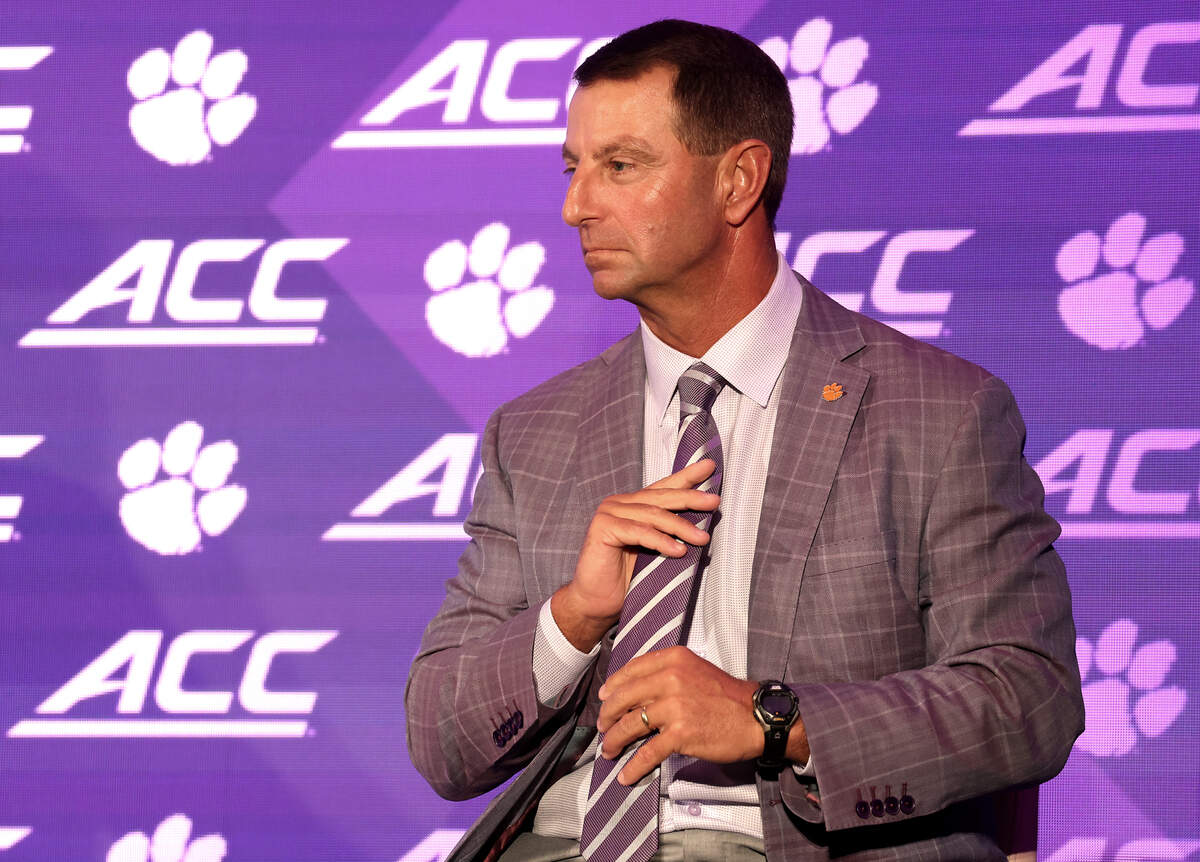 Clemson Tigers head football coach Dabo Swinney adjusts his tie while listening to one of his players speak during the 2026 ACC Football Kickoff program at the Hilton Charlotte Uptown hotel in Charlotte, North Carolina, on Thursday, July 16, 2026.