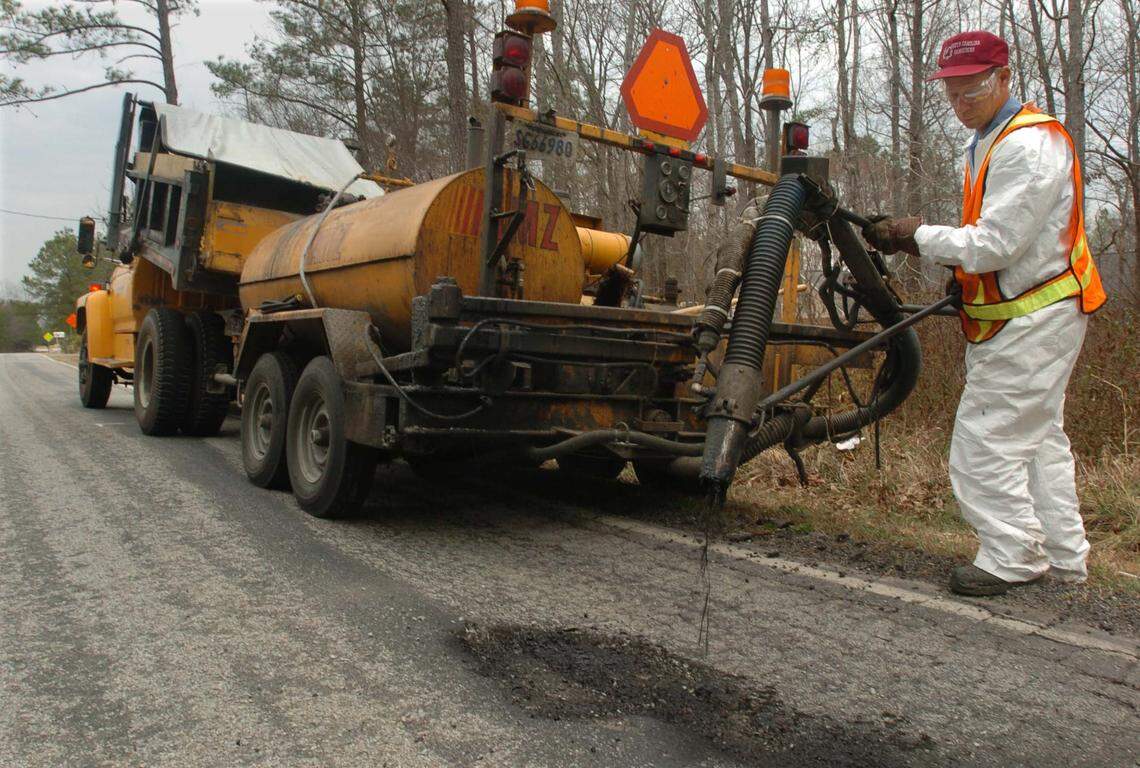 SCDOT employee Joe Davis fills in one of the several potholes on Syrup Mills Road in Blythwood Thursday after the state transportation office received a complain. DOT workers are busy repairing the state-maintained roads. PHOTO BY Takaaki Iwabu / The States