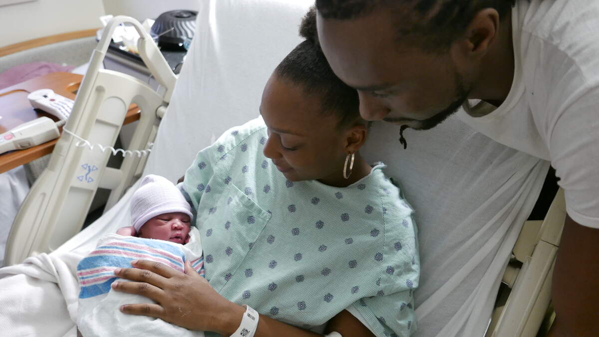 Jarese Woodard (center) and Xavier Gaston with their son, Bryson, who was born at 3:36 a.m. on New Year’s Day.