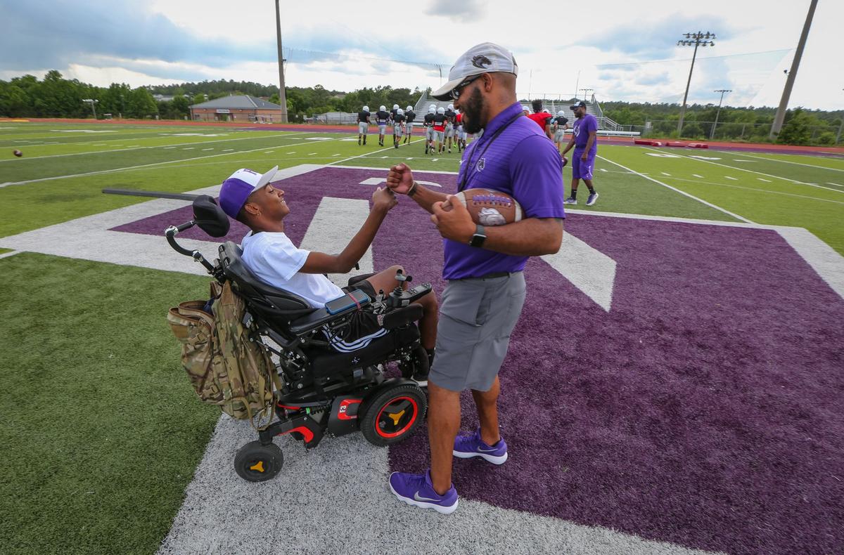 More than two years after paralyzing injury as a player at Westwood High, Mark Mickens back on field as volunteer coach at Ridge View High School. Here, Mickens and Ridge View head coach Perry Parks get ready for practice.