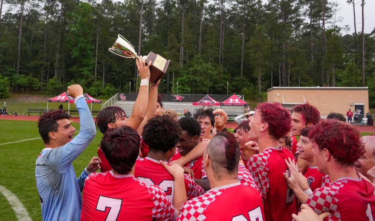 Cardinal Newman players celebrate with the champions trophy after winning the SCISA Class 4A State Boys Soccer Championship game of Cardinal Newman vs Porter Gaud on May 10, 2025. in Columbia.
