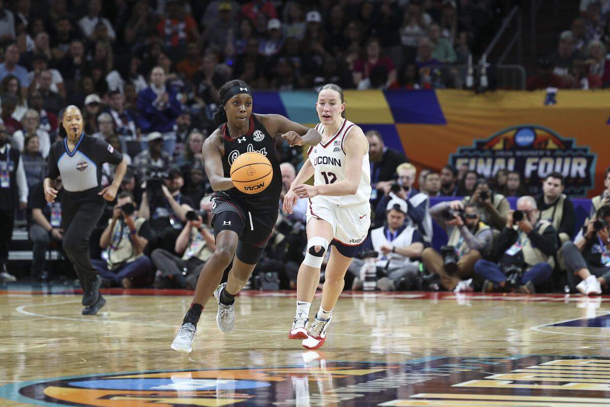 South Carolina's Raven Johnson (25) brings the ball downcourt as University of Connecticut’s Ashlynn Shade (12) follows during the second half of action of their women's basketball game in the NCAA Tournament semifinals against UConn at Mortgage Matchup Center in Phoenix on Friday, April 3.2026. NCAA Tournament semifinals