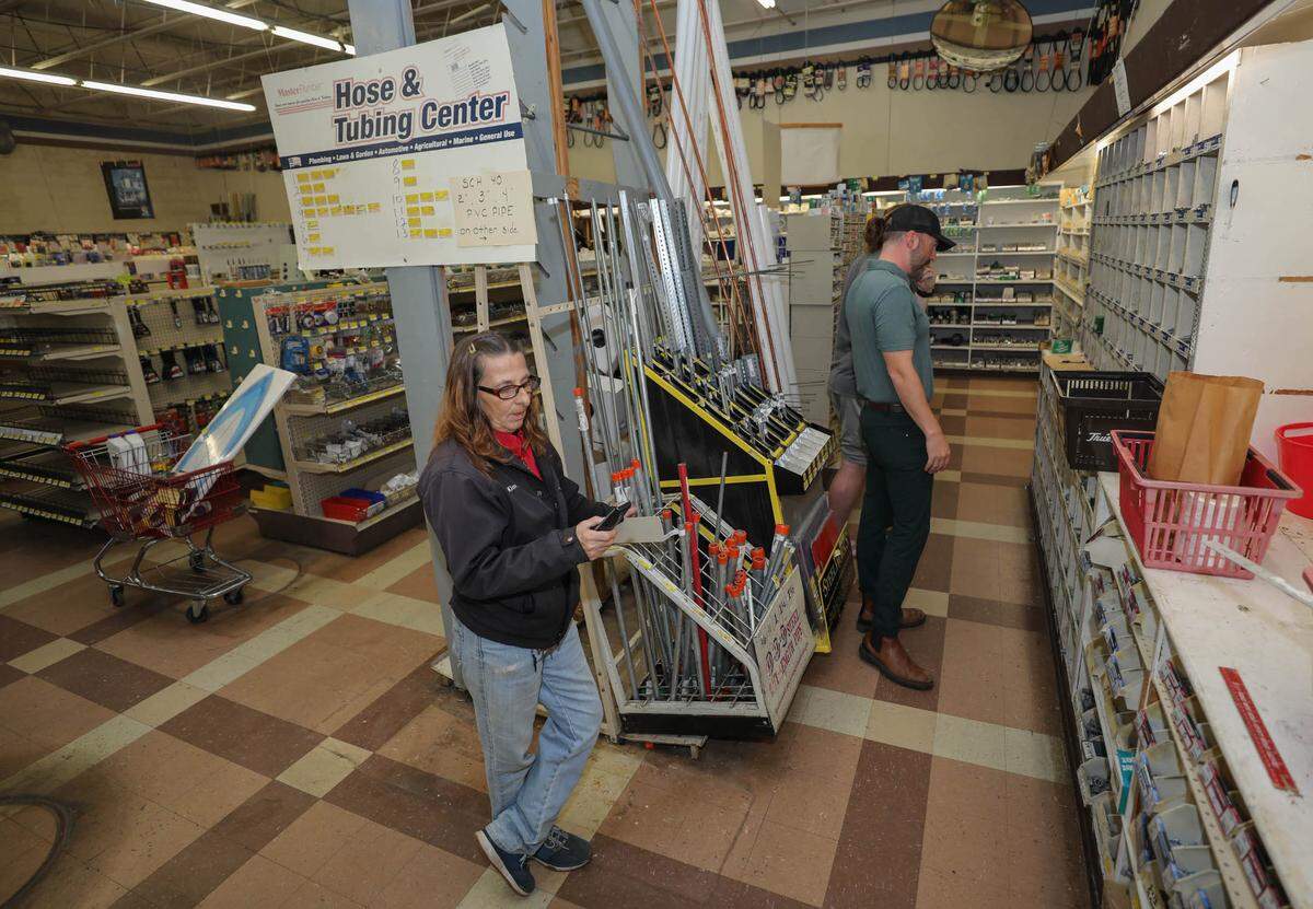 Kim Smart helps Kyle Schoenleber with a purchase at Wood True Value Hardware store on Broad River Rd in Columbia. The store is closing its doors after more than 40 years in business.