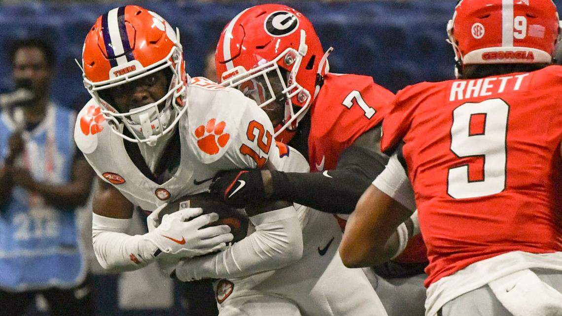 Aug 31, 2024; Atlanta, Georgia, USA; Clemson Tigers wide receiver Bryant Wesco Jr. (12) is tackled by Georgia Bulldogs defensive back Daniel Harris (7) after a catch during the fourth quarter of the 2024 Aflac Kickoff Game at Mercedes-Benz Stadium.