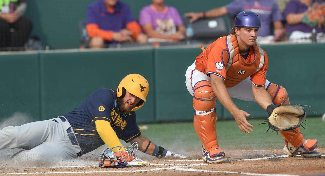 Clemson catcher Jacob Jarrell (9) waits for a throws while West Virginia senior Jace Rinehart (0) scores during the top of the first inning at the NCAA baseball Clemson Regional at Doug Kingsmore Stadium in Clemson, S.C. Saturday, May 31, 2025.
