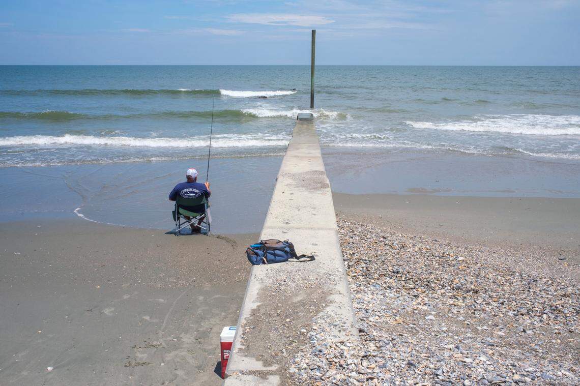 A beachgoer fishes along the groin installed at Debordieu, SC, in an effort to slowdown beach erosion. (Photo July 2024)