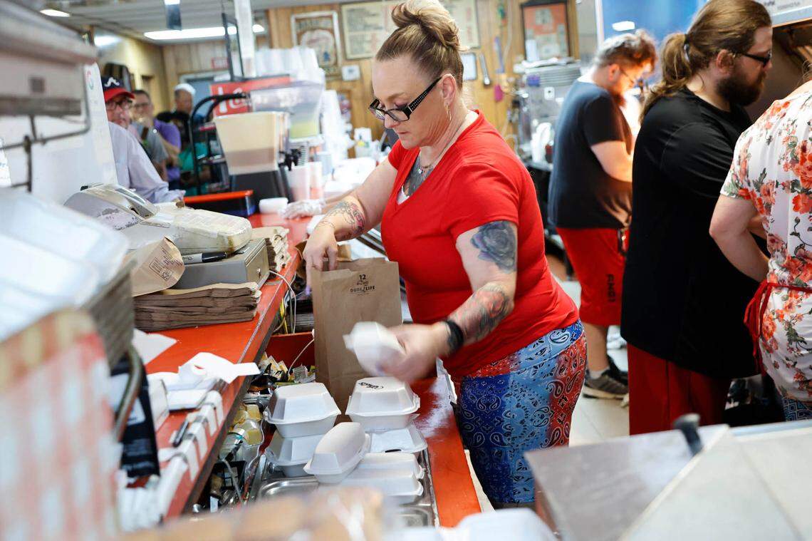 Mack’s Cash Grocery serves 150-200 hot dogs a day. Customers to the restaurant recently voted Mack’s hot dogs as the best hot dogs in the city. Here manager Susan Looney packages an order.