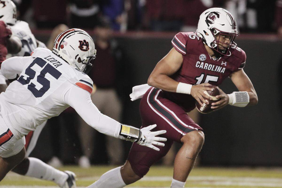 South Carolina quarterback Jason Brown (15) evades Auburn’s Eau Leota (55) on Nov. 20, 2021. 