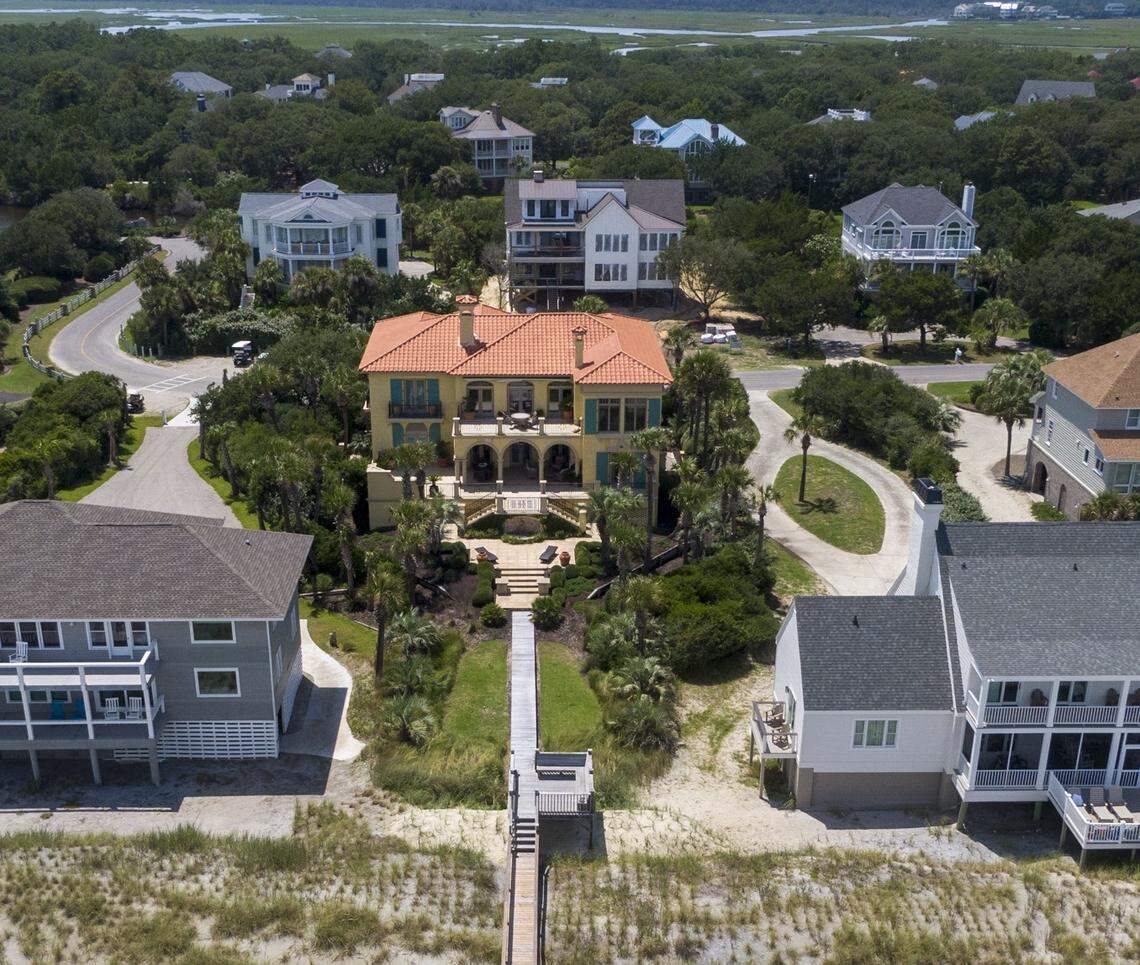 This oceanfront home at Debordieu, S.C., center, is a monument to the dispute over how to protect seaside houses from the rising ocean. A banker bought the house, despite public knowledge it was threatened by the ocean. Fights have ensued over how to prevent the ocean from flooding the house. (July 2024)