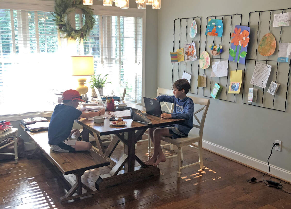 Clemson assistant baseball coach Bradley LeCroy’s sons Cooper (left) and Crew (right) work on schoolwork.