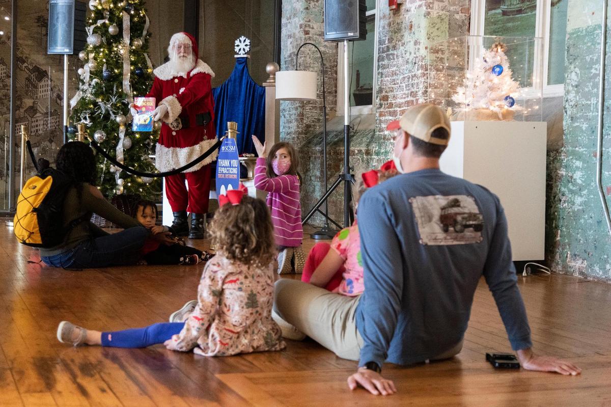 Santa does magic tricks and reads to children at the South Carolina State Museum in Columbia, South Carolina on Saturday, December 12, 2020. Families wore masks and sat apart from one another while watching Santa Claus perform magic tricks.