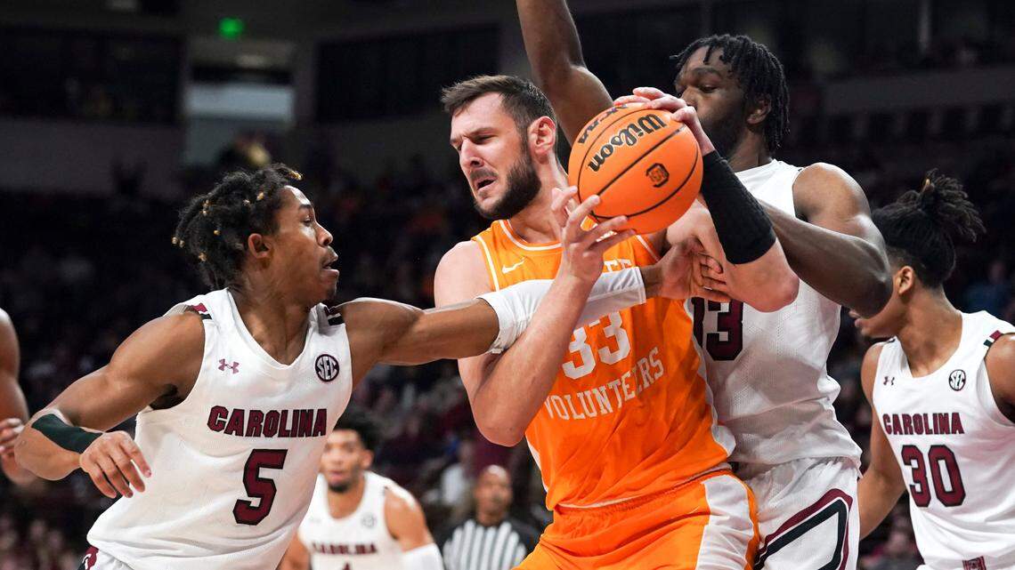 Tennessee forward Uros Plavsic, third from right, is defended by South Carolina guard Meechie Johnson (5) and Josh Gray, second from right, during the first half of an NCAA college basketball game Saturday, Jan. 7, 2023, in Columbia, S.C. (AP Photo/Sean Rayford)