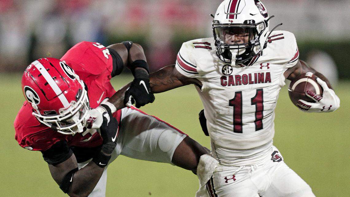 South Carolina Gamecocks running back ZaQuandre White (11) fends off Georgia Bulldogs defensive back Latavious Brini (36) at Sanford Stadium on Saturday, September 18, 2021.
