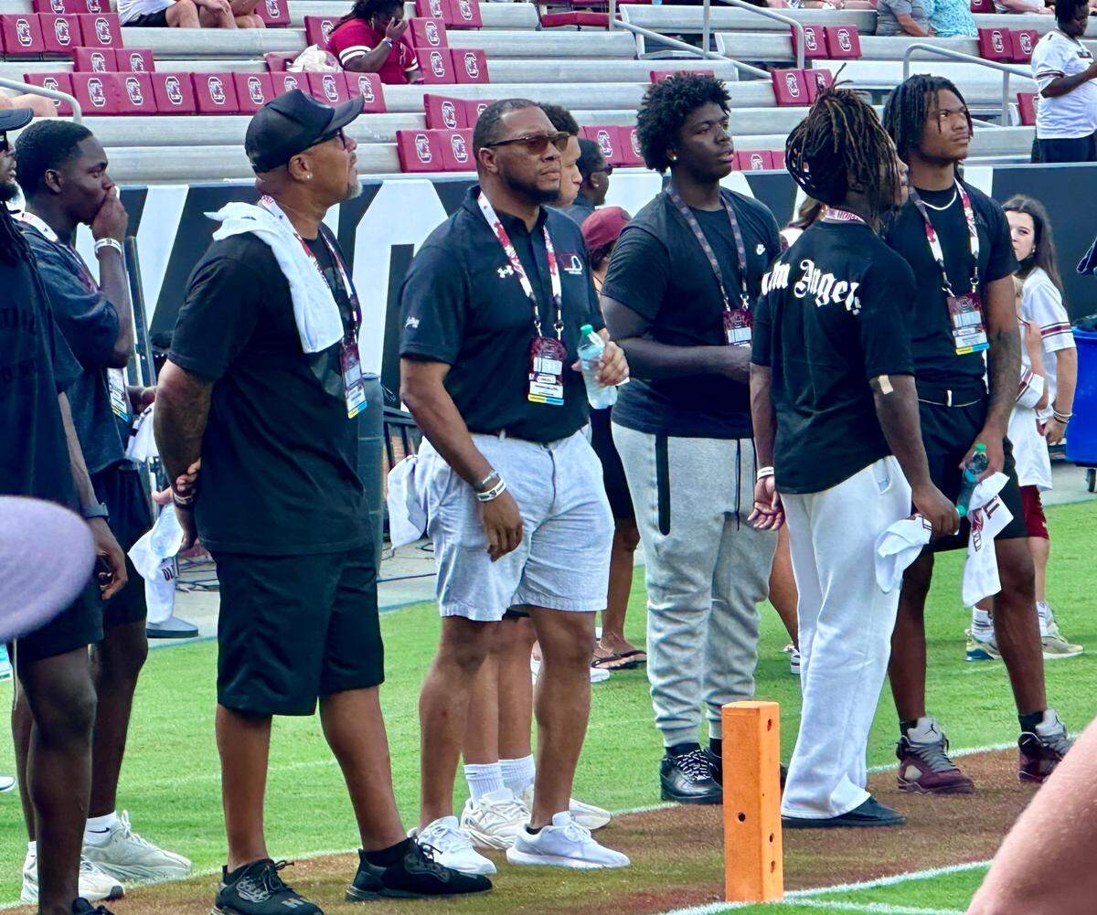 During warmups on Saturday, LaNorris’ Sellers dad, Norris (Middle), and his quarterback coach, Ramon Robinson (Left) stand on the sideline.