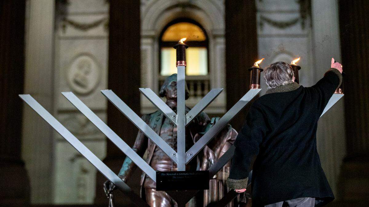 Naomi Farber lights the Isadore E. Lourie Memorial menorah during a celebration on the third night of Chanukah at the South Carolina State House Tuesday Dec. 4, 2018, in Columbia, SC.