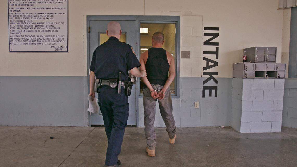 A Lexington County Sheriff’s Deputy leads a suspect to booking at the Lexington County Detention Center