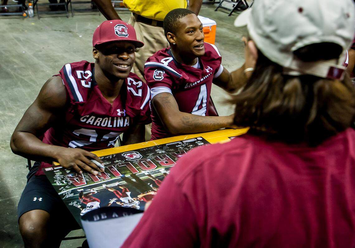 USC wide receivers Bruce Ellington, left, and Shaq Roland sign autographs during the 2013 Fan Appreciation Day at Colonial Life Arena.