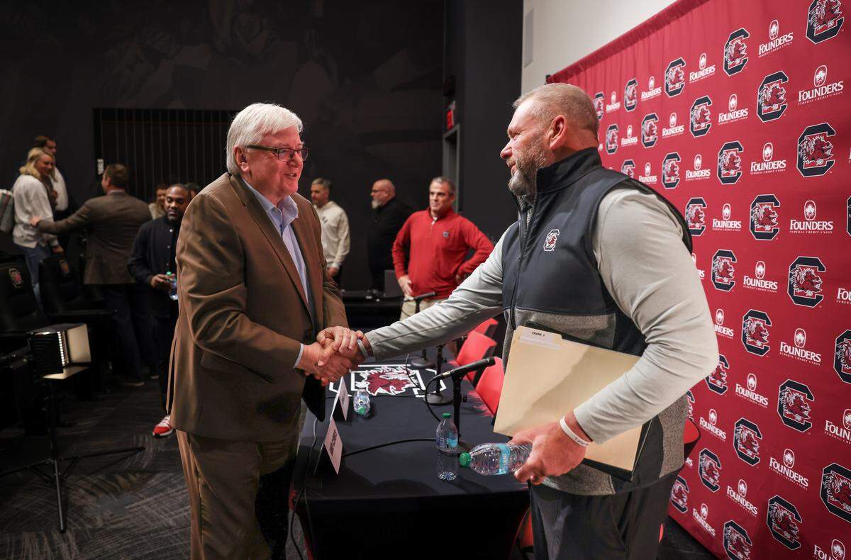 South Carolina offensive line coach Randy Clements speaks to president Michael Amiridis following a press conference in Columbia on Friday, December 12, 2025.