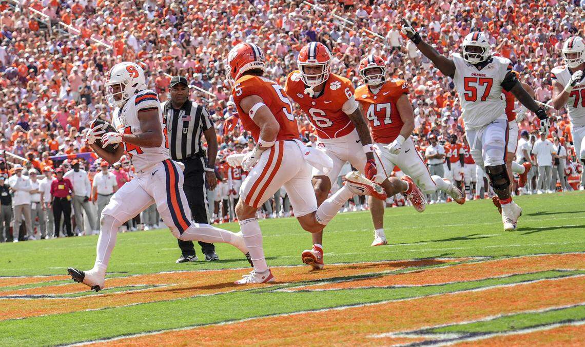 Syracuse Orange running back Will Nixon (24) scores near Clemson Tigers defensive back Ronan Hanafin (5), cornerback Ricardo Jones (6) and linebacker Sammy Brown (47) during the second quarter at Memorial Stadium.