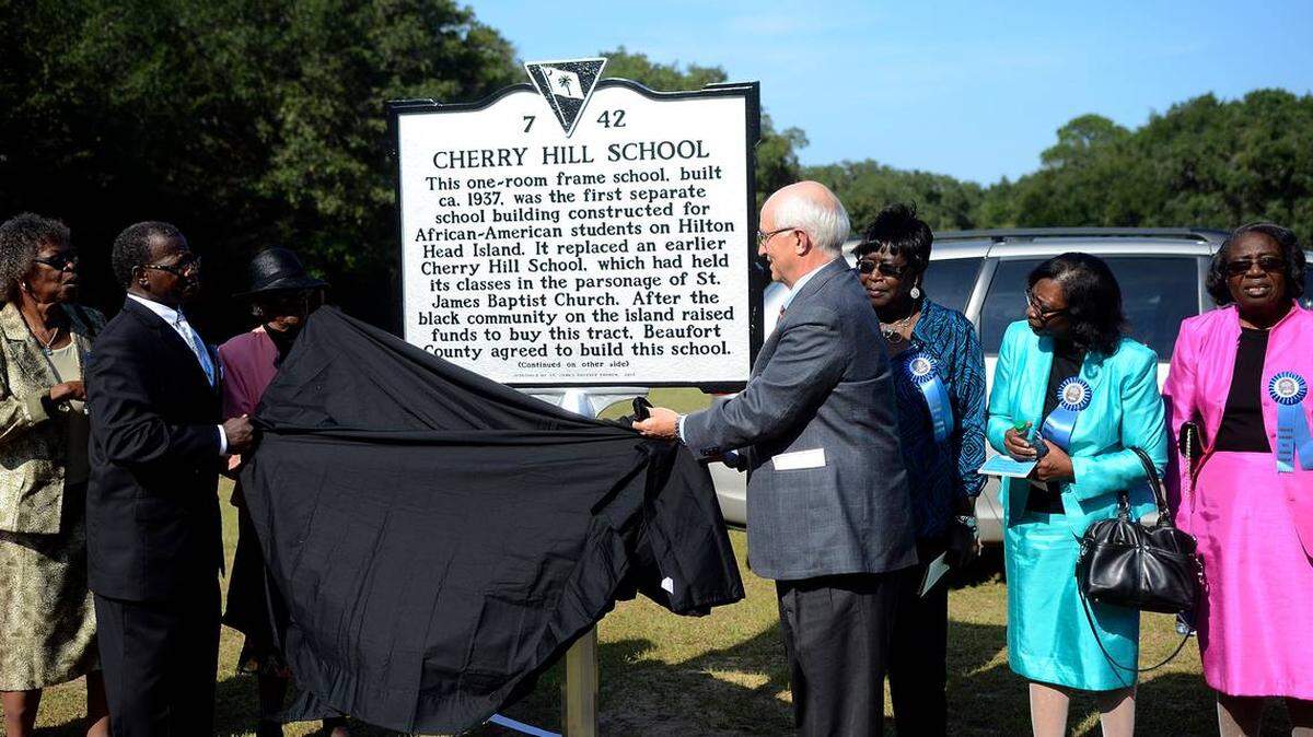 The late Rev. Charles E. Hamilton Sr then pastor of St. James Baptist Church, left, and then-Hilton Head Island Mayor Drew Laughlin, right, unveil the South Carolina historical marker for Cherry Hill School on Sept. 20, 2013, at the school on Hilton Head Island.