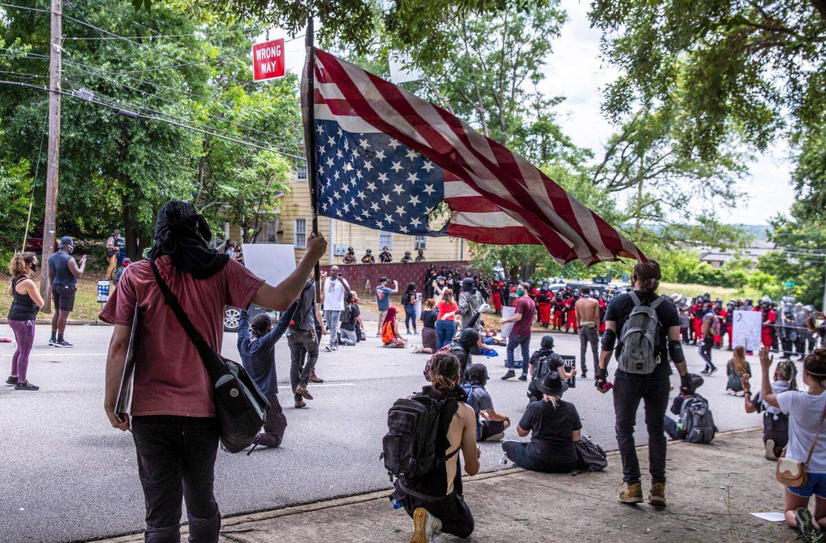 John White holds an upside down flag in protest during a stand off with Columbia police on Sunday. May 31, 2020