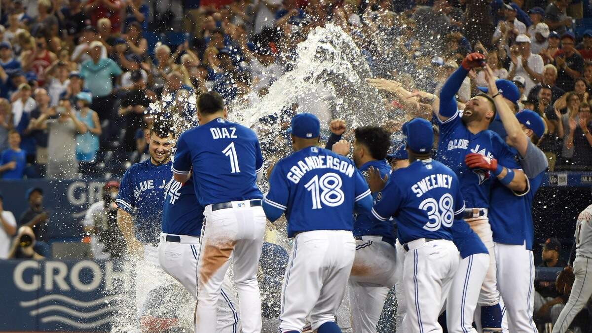 Jun 30, 2018; Toronto, Ontario, CAN;  Toronto Blue Jays first baseman Justin Smoak (14) is greeted at home plate by team mates after hitting a walk off home run against Detroit Tigers in the ninth inning at Rogers Centre.